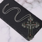Collar con colgante de crucifijo clásico ornamentado con iconografía de todos los santos y gemas rojas