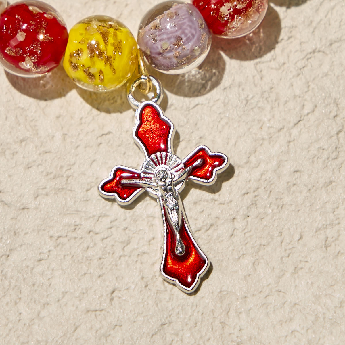 Pulseras de cristal coloridas que brillan en la oscuridad con motas doradas y crucifijo