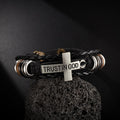 Pulsera de cuero trenzado negro con cruz e inscripción CONFIANZA EN DIOS