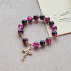 Pulsera Grace and Strength de cuentas de cristal negras y rosas con cruz dorada