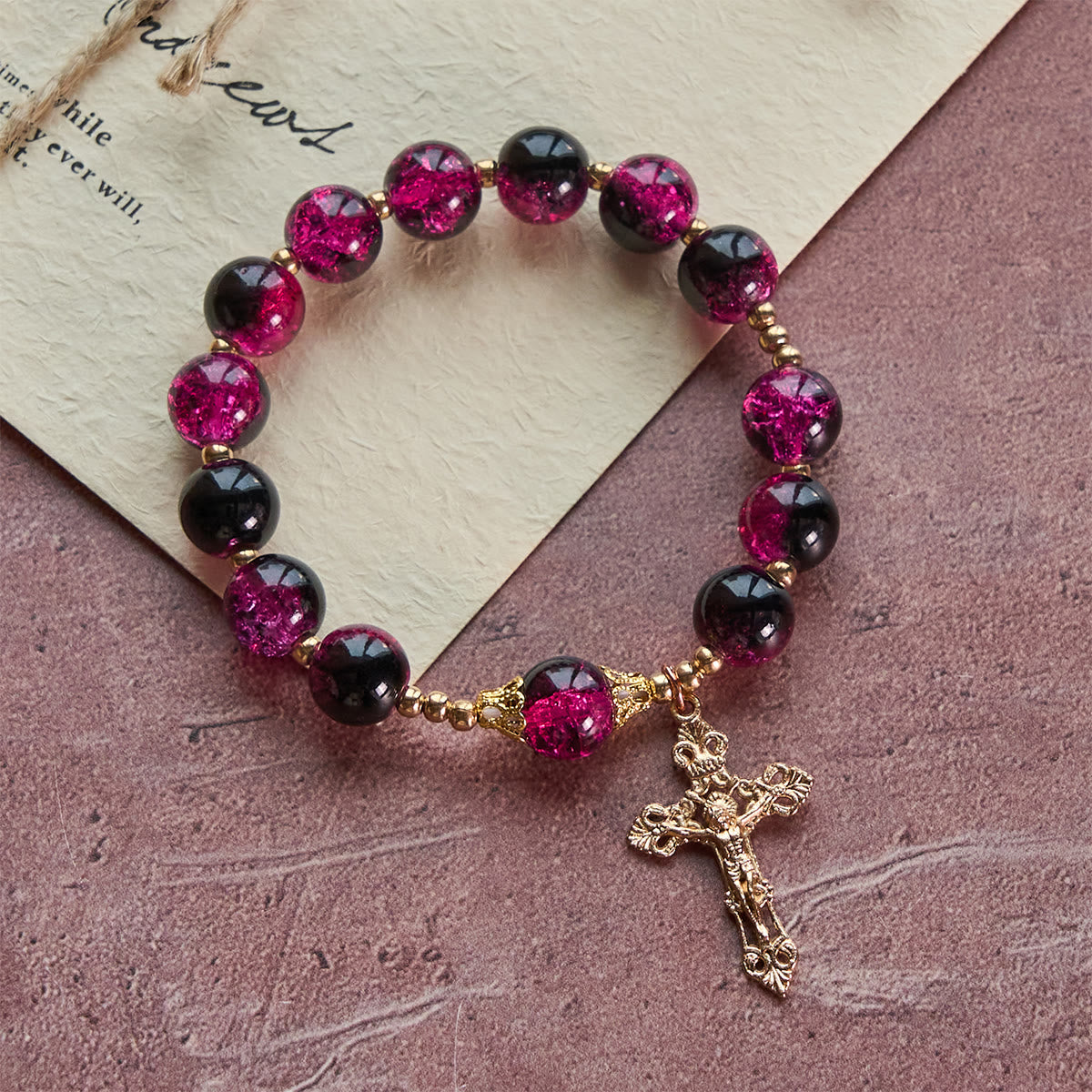 Pulsera Grace and Strength de cuentas de cristal negras y rosas con cruz dorada