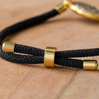Pulsera ajustable con cordón negro y medalla de San Benito