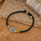 Pulsera ajustable con cordón negro y medalla de San Benito