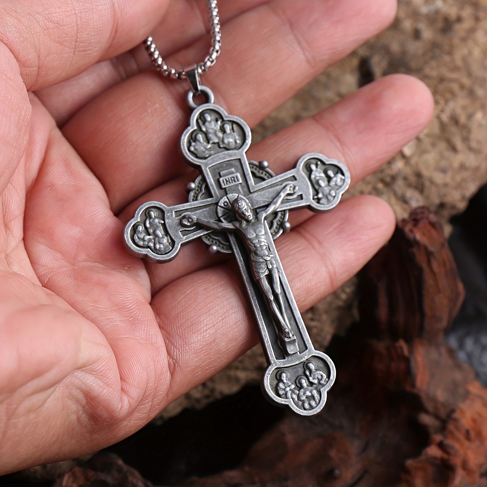 Collar con cadena de eslabones y crucifijo ornamental con silueta de Jesús: un símbolo de la redención de Cristo