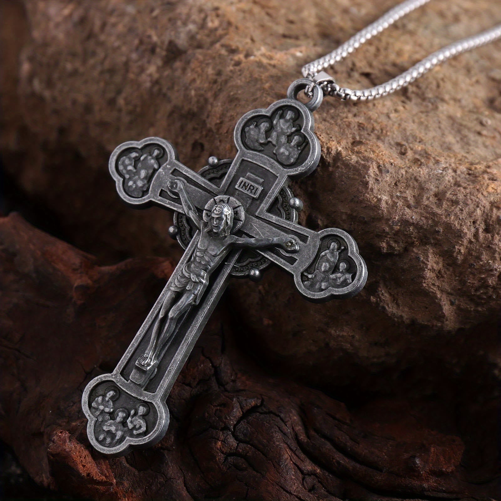 Collar con cadena de eslabones y crucifijo ornamental con silueta de Jesús: un símbolo de la redención de Cristo
