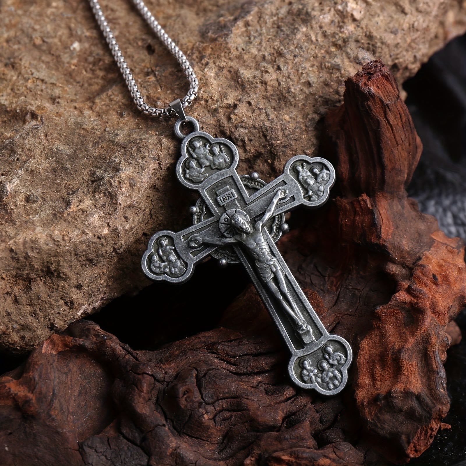Collar con cadena de eslabones y crucifijo ornamental con silueta de Jesús: un símbolo de la redención de Cristo