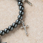 Pulsera de Cuentas de Hematita con Cruz y Dijes de Mini Crucifijos: Un Símbolo de Protección Divina y Fe