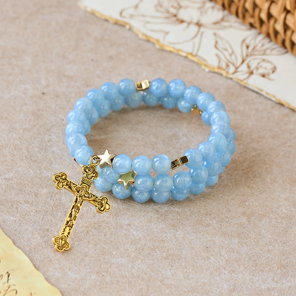 Pulsera enrollable de cuentas de cristal azul con espaciadores de estrella y crucifijo dorado