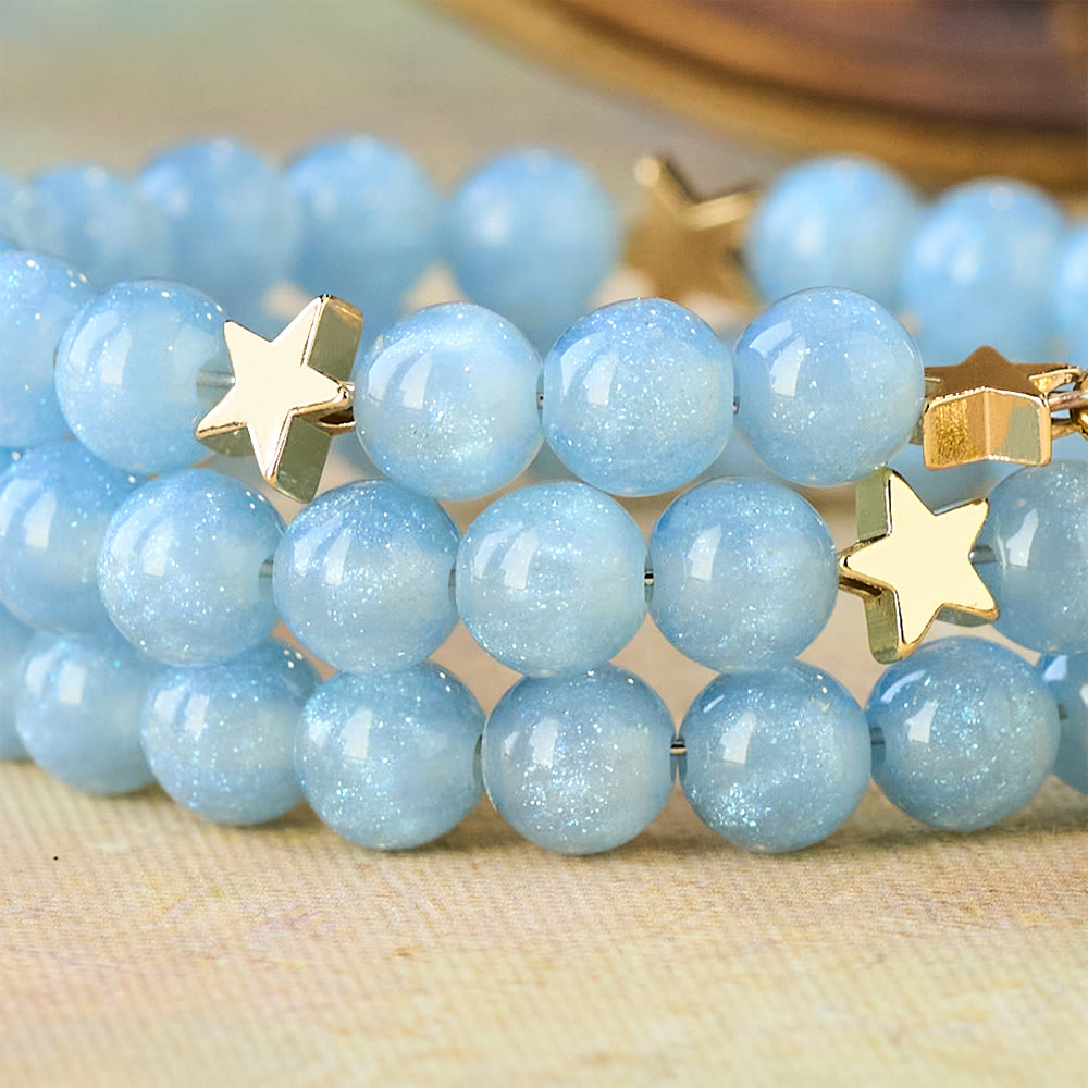 Pulsera enrollable de cuentas de cristal azul con espaciadores de estrella y crucifijo dorado