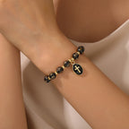 Pulsera de Cuentas Cruzadas de Acrílico Bicolor con Dije de Cruz Esmaltada: Un Vaso para la Fe Diaria Sagrada